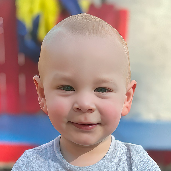 A young child with a gentle smile poses happily, capturing a playful outdoor moment.